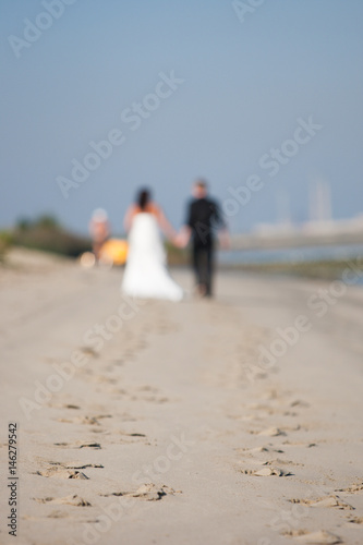 Unrecognizable newlywed couple walking on a beach
