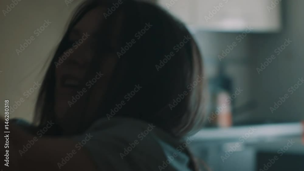 Young funny caucasian brunette woman lifts up heavy fallen clothes rack in early morning against bright window, close up slow motion Young funny caucasian brunette woman lifts up heavy fallen clothes rack in early morning against bright window, close up slow motion