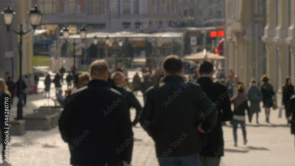 Blurred unrecognizable people walk along sunny spring street slow motion video Blurred unrecognizable people walk along sunny spring street slow motion video