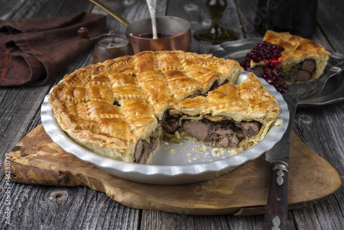 Vanison Pie with Cranbeery Relish as close-up in a backing dish photo