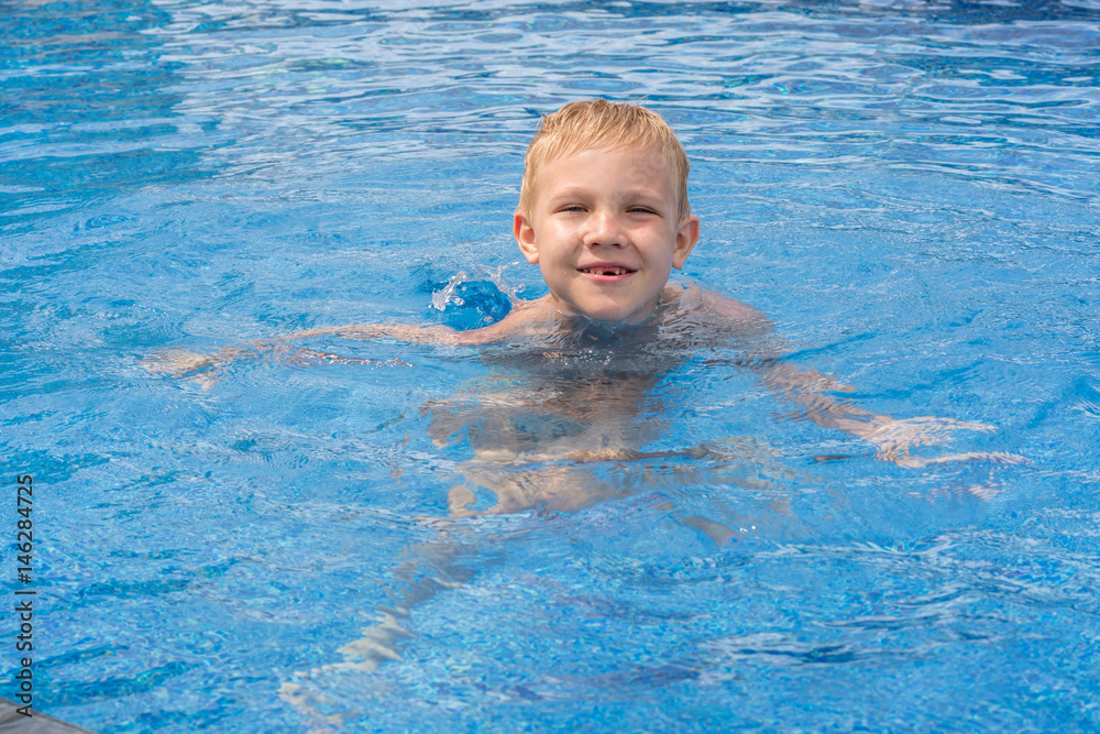 Boy swimming and playing in a pool