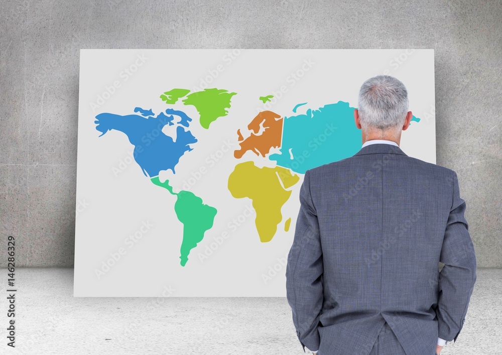 Businessman looking at Colorful Map with wall background Businessman looking at Colorful Map with wall background