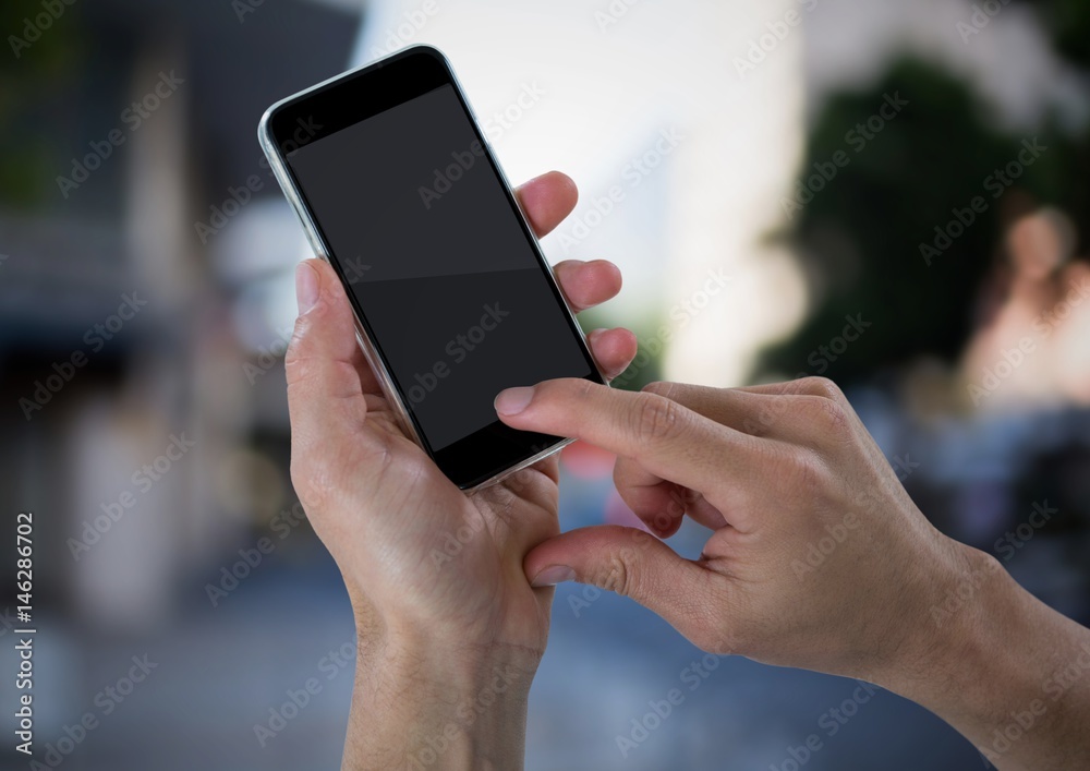 Hands with phone against blurry street Hands with phone against blurry street
