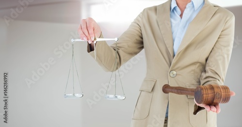 Judge with balance scale and hammer in front of window light