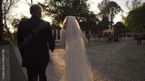 Father leads a pretty bride to an engagement ceremony