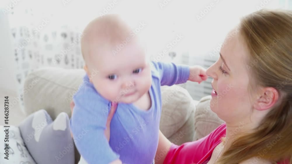 Pretty mother playing with her 6 months son closeup Pretty mother playing with her 6 months son closeup
