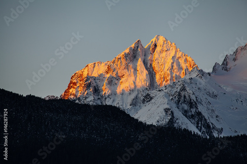 Dramatic Mountain Peak Rising Over Dark Forest Ridge, Haines Alaska photo
