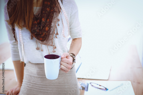 Female fashion designer with cup of coffee photo