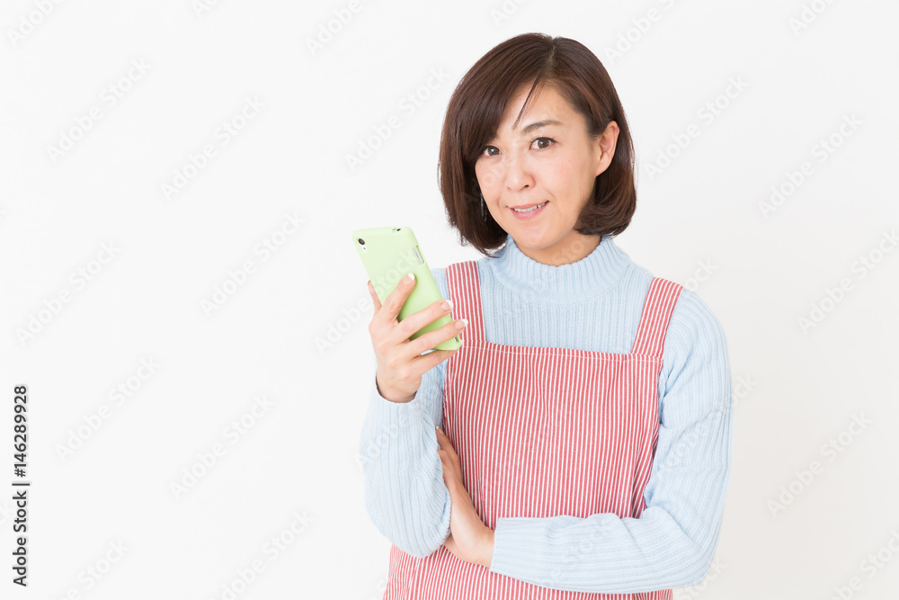 エプロンをしたミドル女性 スマホ エプロンをしたミドル女性 スマホ