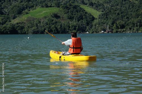 Boy paddling kayak in the sea