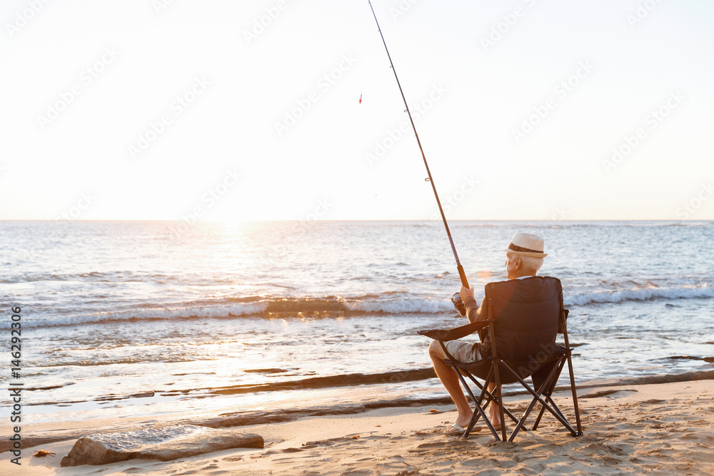 Fototapeta premium Senior man fishing at sea side