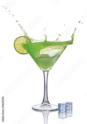 Splash in glass of green mint alcoholic cocktail drink with lime and ice cube