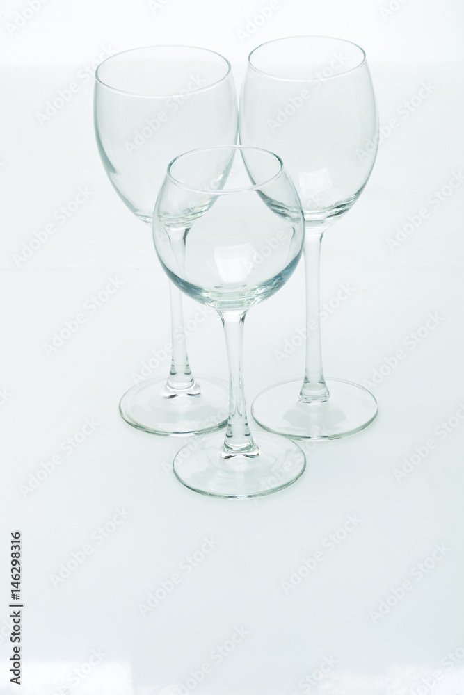 Grapes and three glasses for wine on a white background, studio light Grapes and three glasses for wine on a white background, studio light