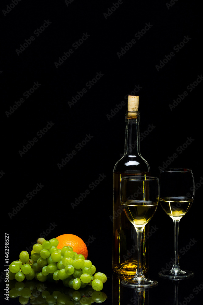 Glasses for wine, grapes and oranges on a black background