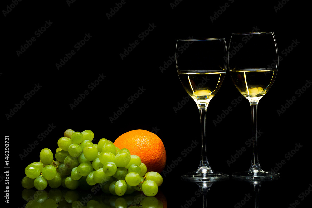 Glasses for wine, grapes and oranges on a black background Glasses for wine, grapes and oranges on a black background