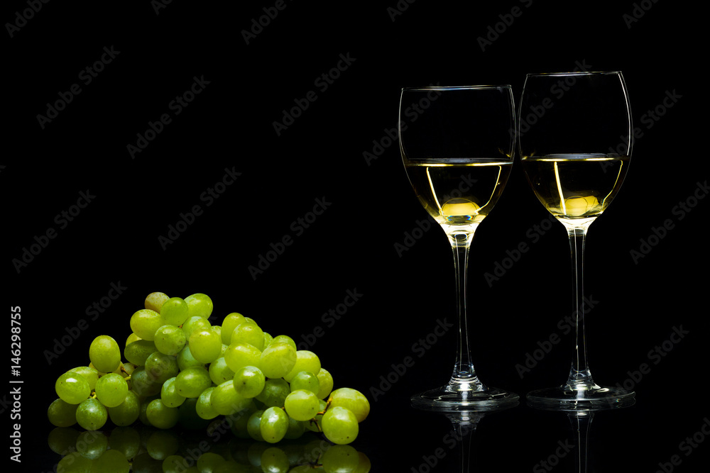 Glasses for wine and a bunch of grapes on a black background Glasses for wine and a bunch of grapes on a black background