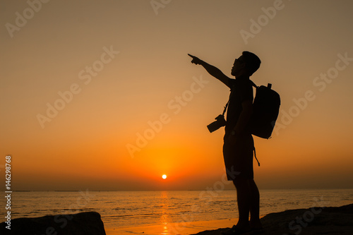 Silhouette of Male photographer standing On the beach at sunset
