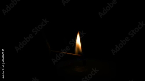 lighting a candle with a match in a dark space