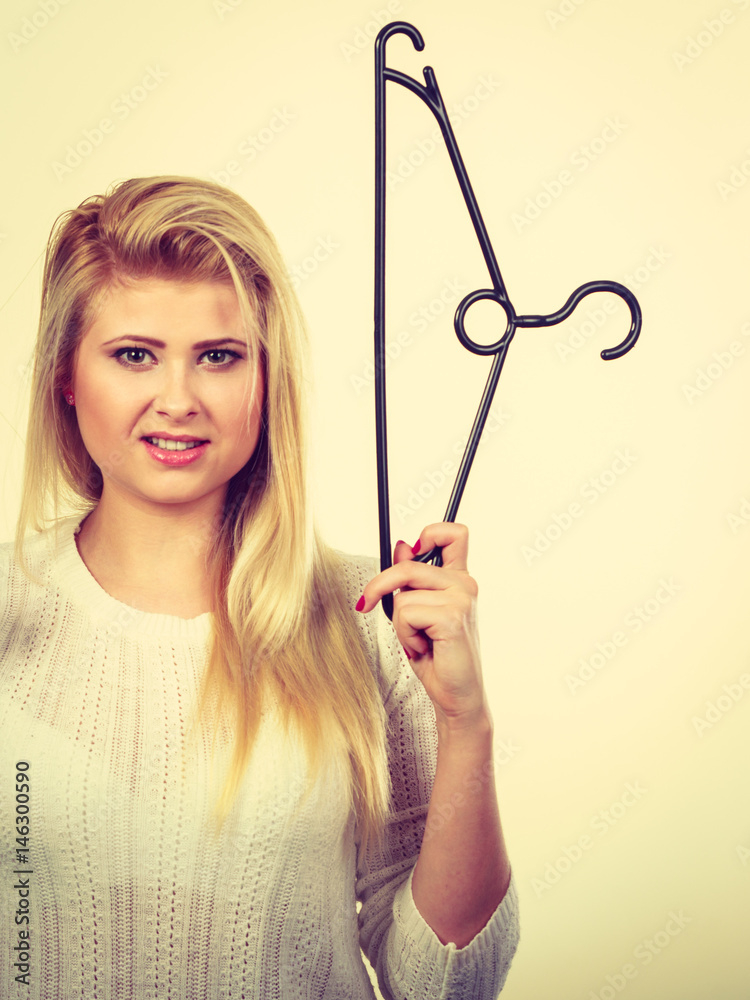 Blonde woman holding clothes hanger