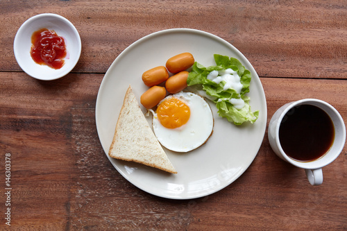 Quick and easy breakfast, fried eggs with sausages, toast and salad.