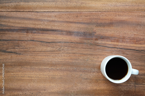 Black coffee mug on the wooden table with copy space.