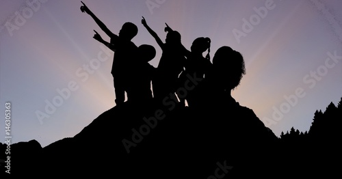 Silhouette children pointing towards sky