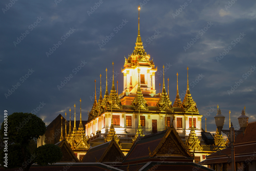 Naklejka premium A view of the top of Chedi Loha Prasat (Metal Palace) of the Buddhist temple of Wat Ratchanadda in the evening twilight. Bangkok, Thailand