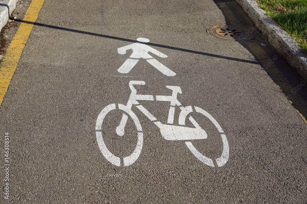 White painted bicycle way sign on asphalt in park. White painted bicycle way sign on asphalt in park.