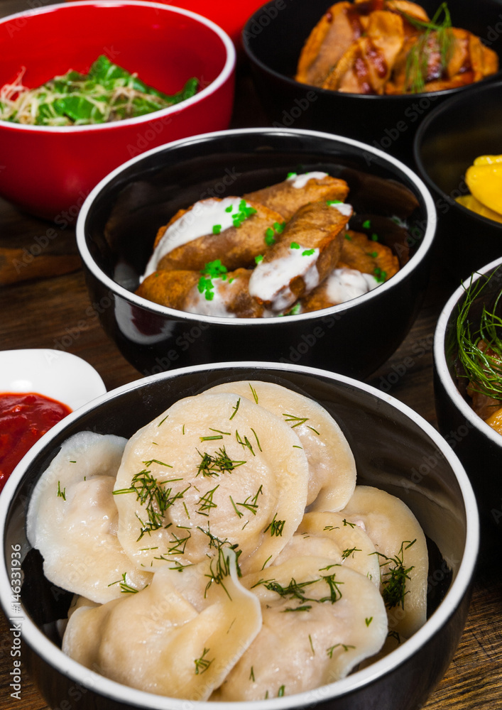 Set of different dumplings and ravioli on a wooden table Set of different dumplings and ravioli on a wooden table