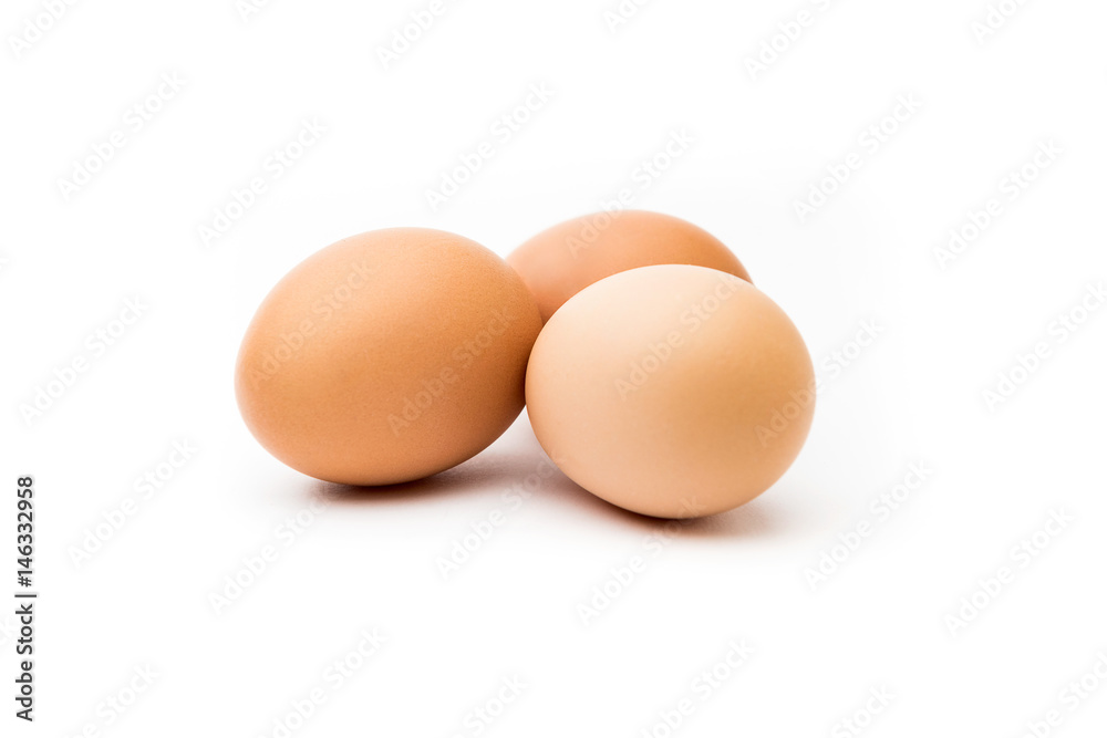 Tres huevos morenos con fondo blanco Tres huevos morenos con fondo blanco
