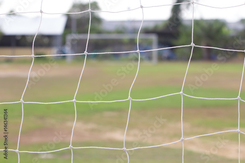  Football field  with  blurred a white goal in the background.