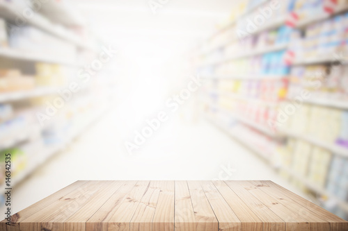 Wood table top with supermarket background