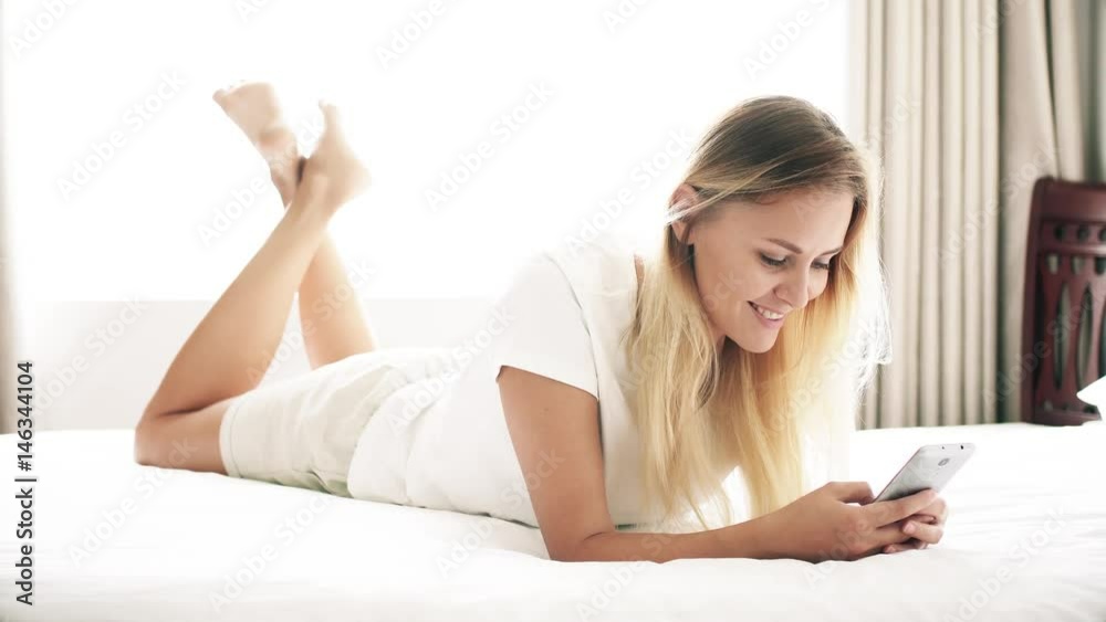 Woman using app on smartphone. Smiling and texting on mobile phone. Woman using app on smartphone. Smiling and texting on mobile phone.