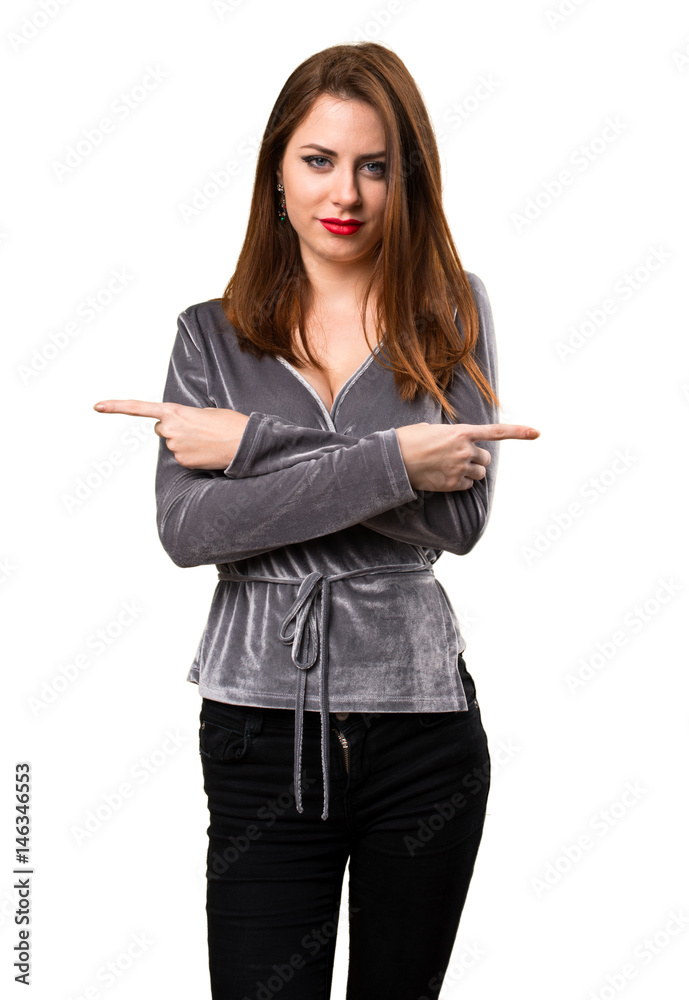 Beautiful young girl pointing to the laterals having doubts Beautiful young girl pointing to the laterals having doubts
