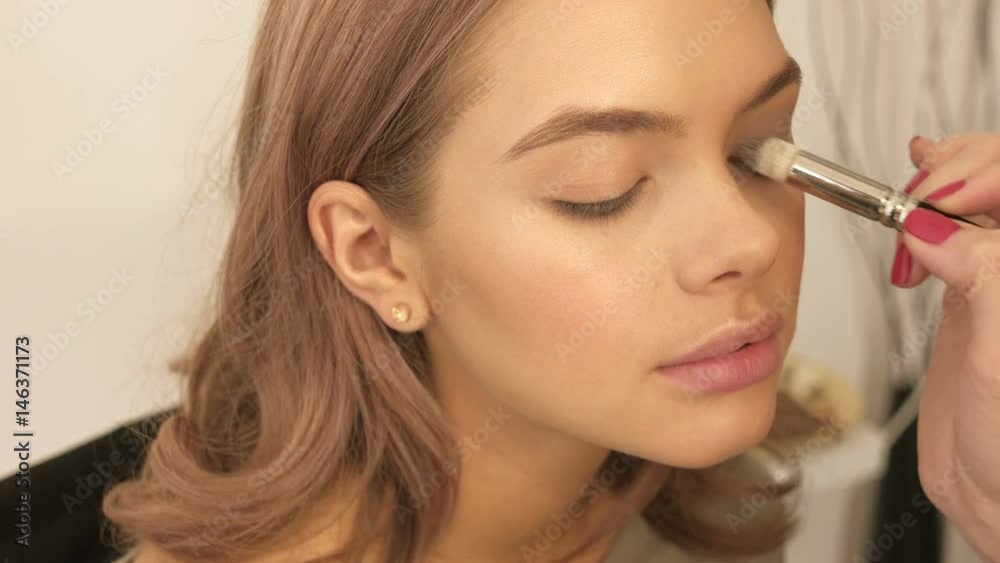 Makeup artist makes models eye makeup. Gentle make-up for the young girl. Makeup artist makes models eye makeup. Gentle make-up for the young girl.