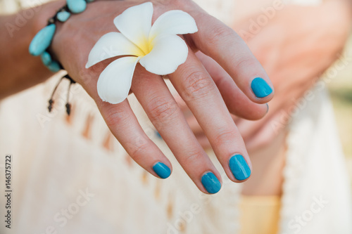 White plumeria Flower on hand With a turquoise bracelet. photo