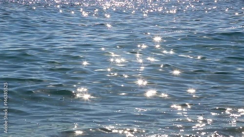 Beautiful blue sea water background with bright sunny sparkles on surface of waves. Real time full hd video footage.