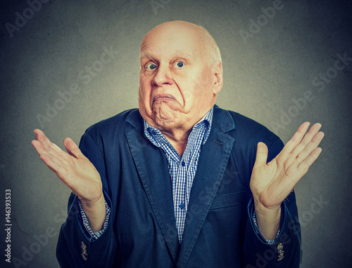 Senior confused man is shrugging his shoulders