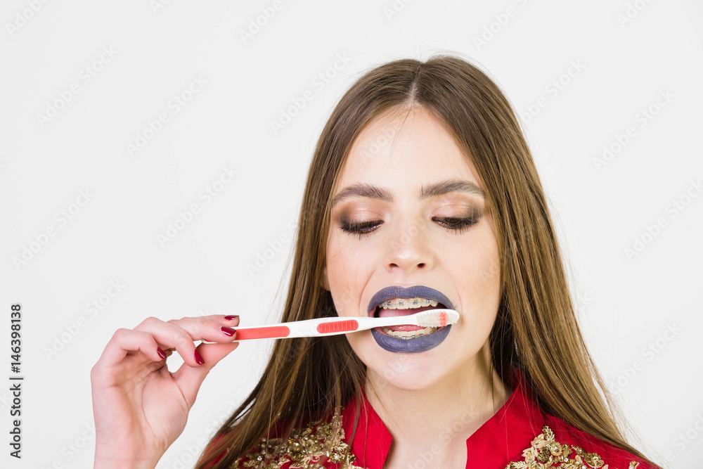 girl with teeth braces and brush, has fashionable makeup girl with teeth braces and brush, has fashionable makeup