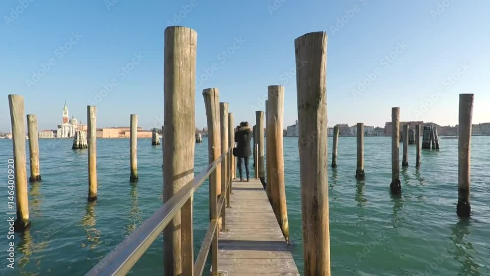 Girl is standing on the boats wharf, Venice, Italy Girl is standing on the boats wharf, Venice, Italy
