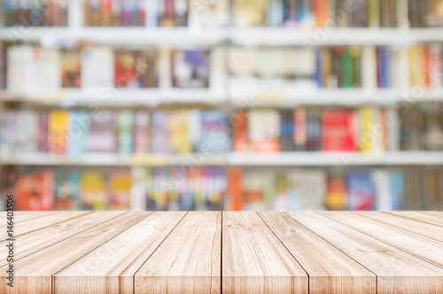 Empty wooden table top with Blur bookshelves in bookstore background. photo