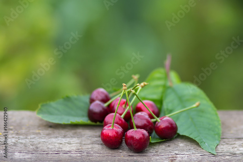 Red cherry fruits on wooden table background