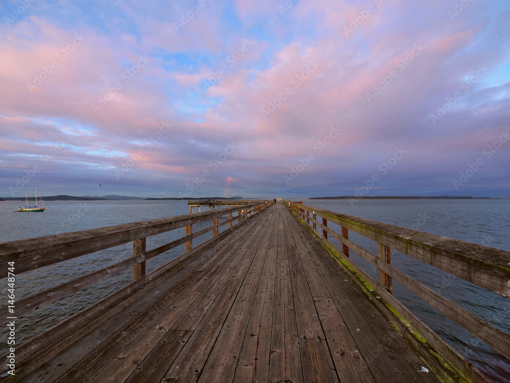 Obraz premium Wooden fishing pier extending from the shore into the ocean. Sidney BC, Vancouver Island