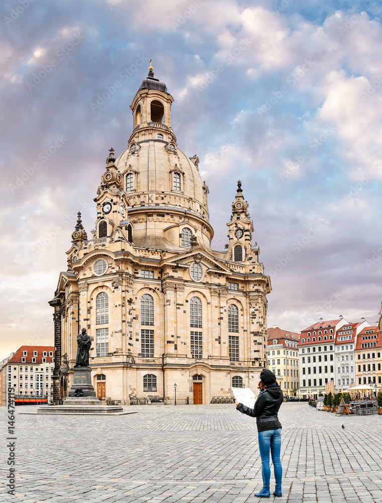 Woman tourist with the map near famous landmark of the Dresden city - Frauenkirche Church of Our Lady