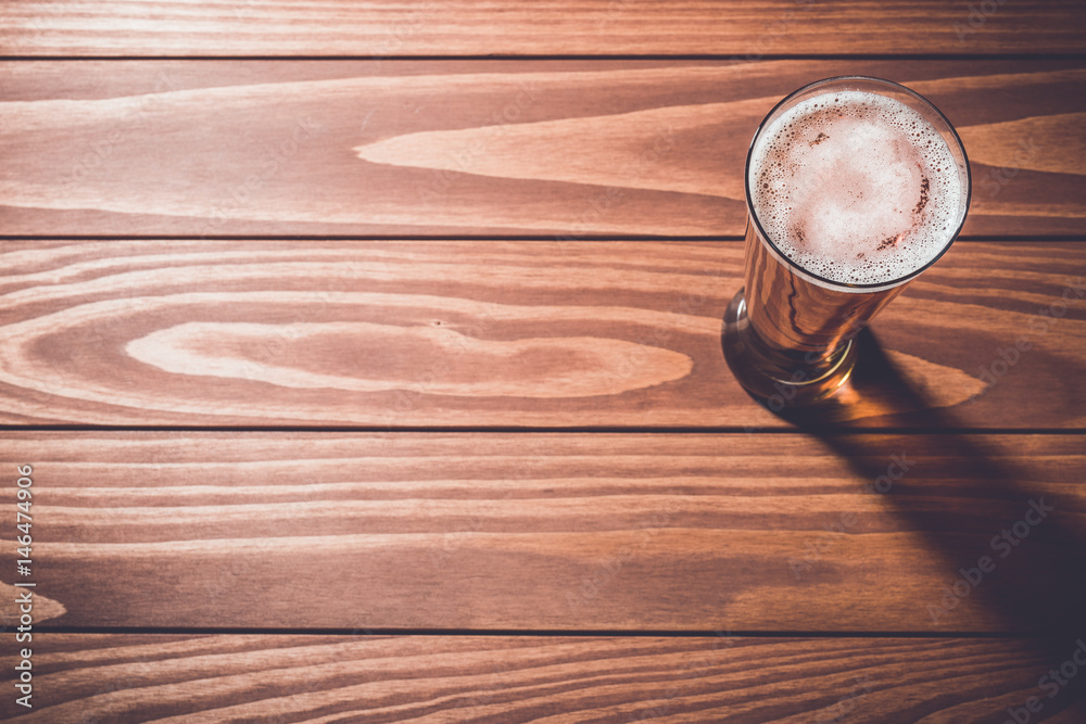 Overhead shot of beer glass on wooden table. Close up Overhead shot of beer glass on wooden table. Close up