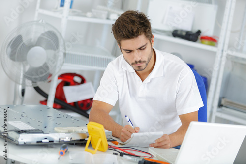 young engineer taking notes while developping new induction hobs photo