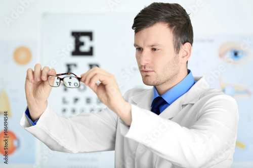 Male doctor holding glasses...