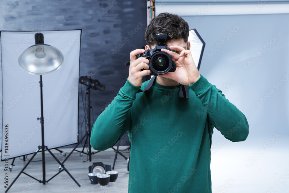 Obraz premium Young professional photographer with camera in studio