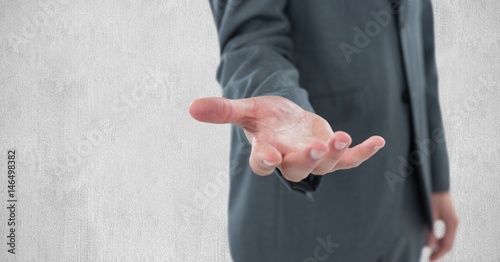 Midsection of businessman gesturing against wall