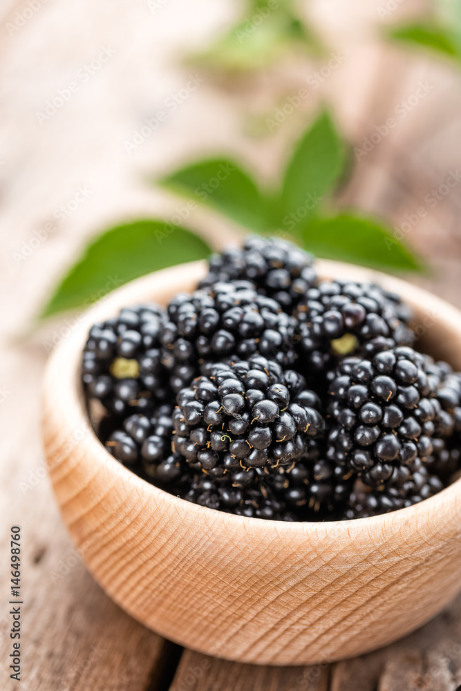 Fresh blackberry with leaves on wooden background close up Fresh blackberry with leaves on wooden background close up